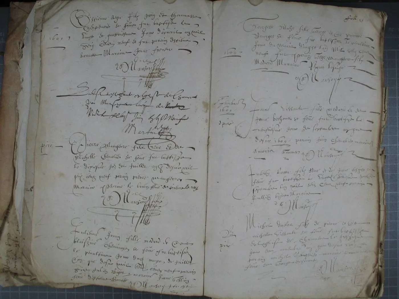 Double page du registre paroissial de Chaumeré, année 1609 : à gauche un baptême, puis la mention de la visite de l'évêque signée « Martin », puis deux baptêmes ; à droite quatre baptêmes, avec des mots ajoutés dans la marge ; la signature « Manson » revient sous chaque acte de baptême